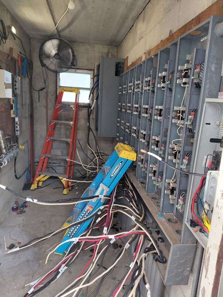 Meter Bank Wiring In Progress — Breakers Loaded, Wires Pulled, Ladders on Site