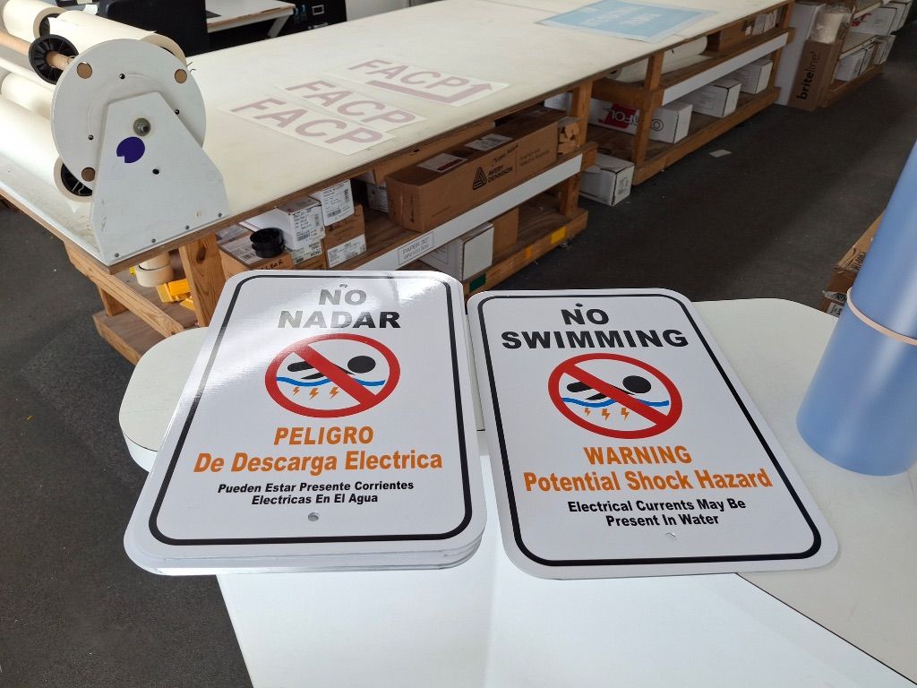 ESD Warning Signs — No Swimming, Warning Potential Shock Hazard — English and Spanish