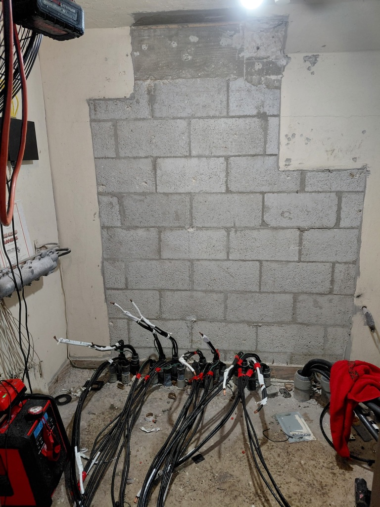 Before — Wall Cleared, Service Cables Staged on CMU Floor, No Meter Bank Yet — PSEC Install 1