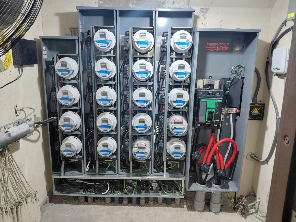 Install 1 During — Meter Bank Covers Off, Internal Wiring and Main Disconnect Visible, 20 Digital Meters Seated — PSEC